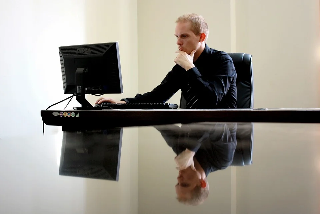 Image d'un homme devant un ordinateur